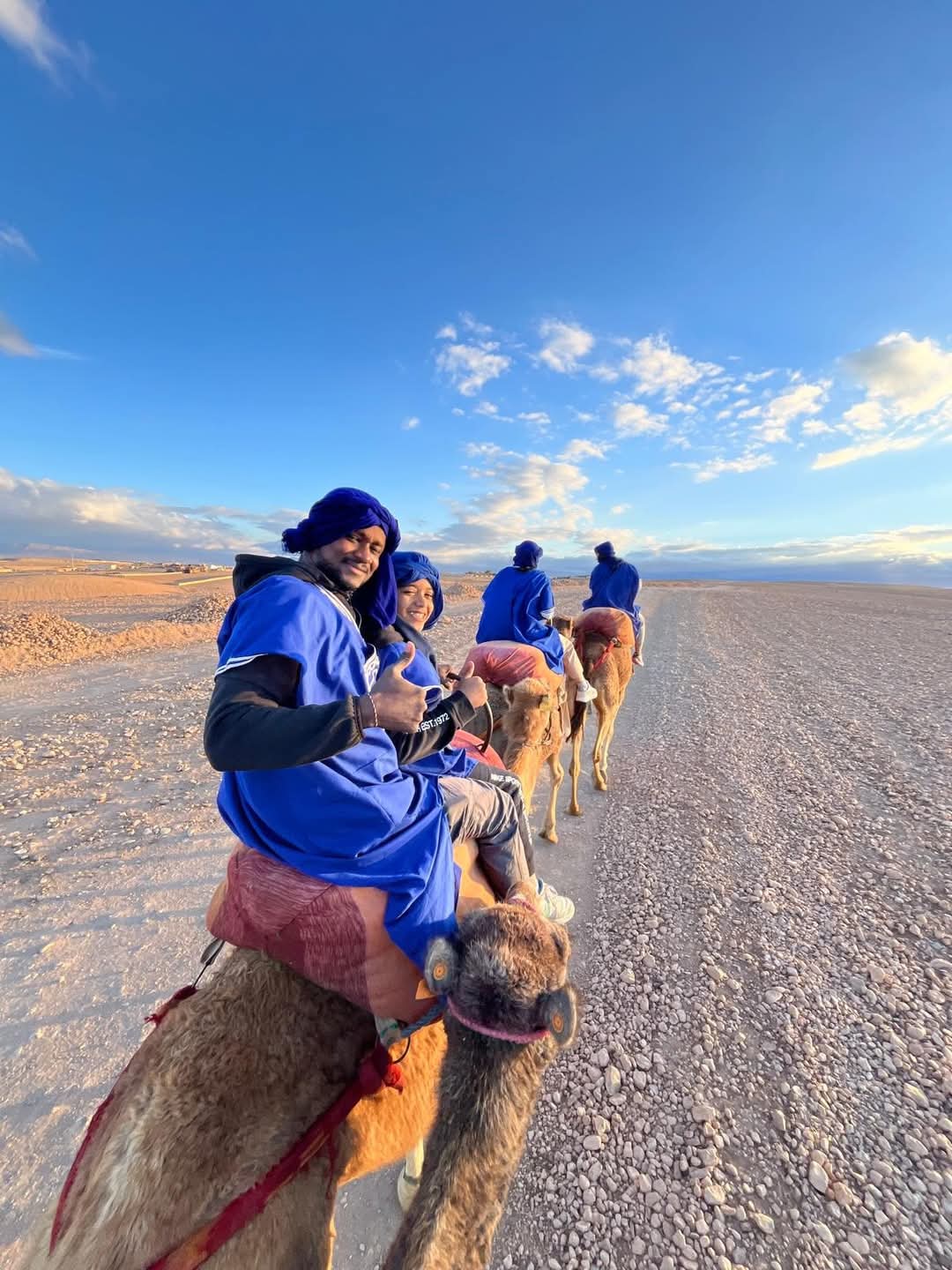 Couple en tenues berbères sur des chameaux dans le désert