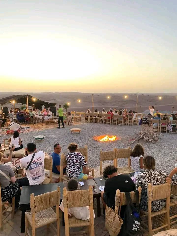 Dîner au camp du désert avec feu de camp et tables traditionnelles