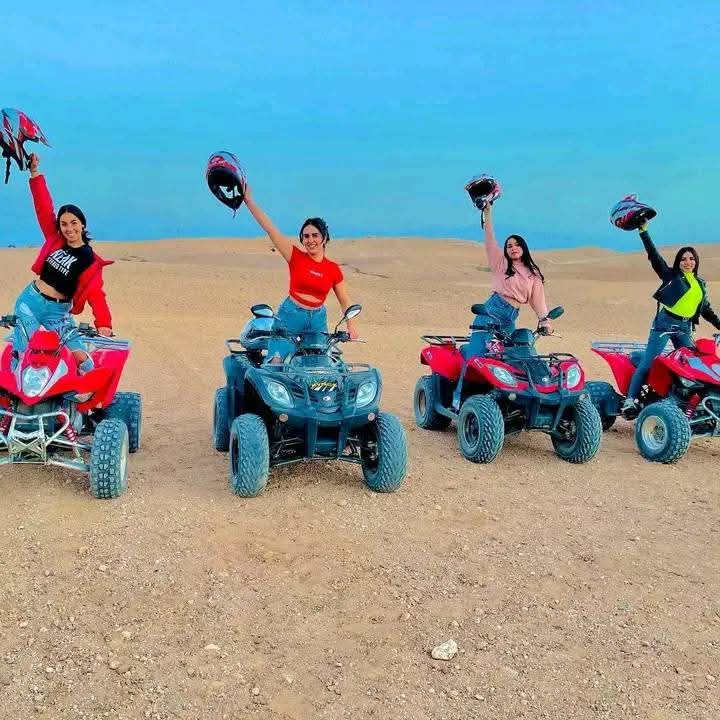 Quatre femmes célébrant avec leurs quads colorés dans le désert